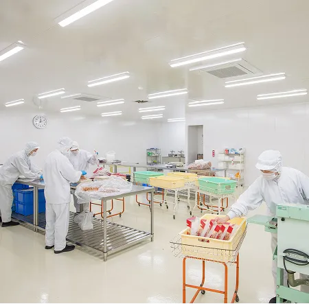 清潔な作業所内で白衣のスタッフが作業する様子